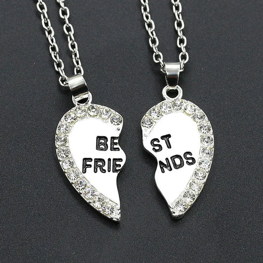 Two silver heart-shaped pendants with 'BEST FRIENDS' on a dark background